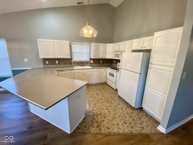 kitchen with high vaulted ceiling, hanging light fixtures, hardwood / wood-style floors, white cabinets, and white appliances