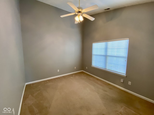 carpeted spare room featuring ceiling fan