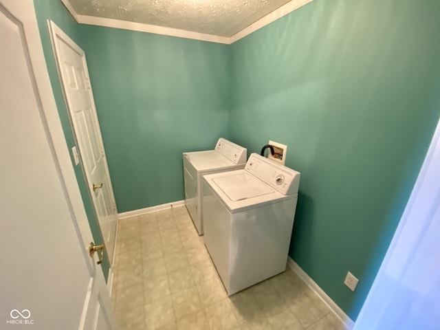 laundry area featuring washing machine and dryer, a textured ceiling, and crown molding