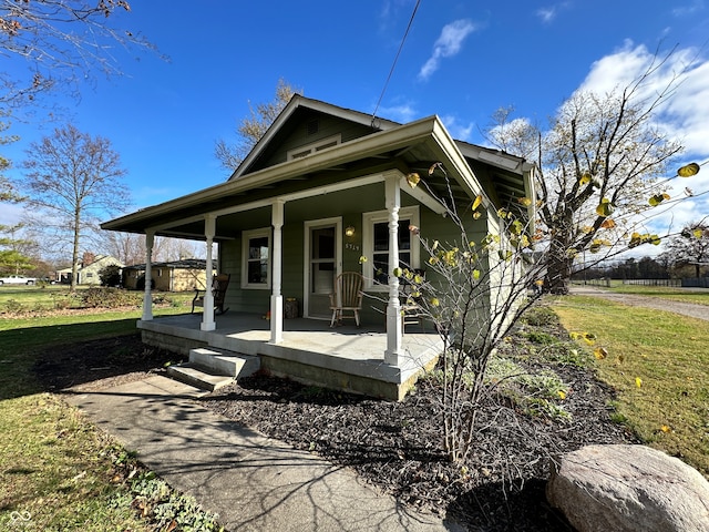 exterior space with covered porch and a front yard