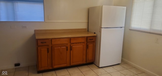 kitchen with light tile patterned floors and white fridge