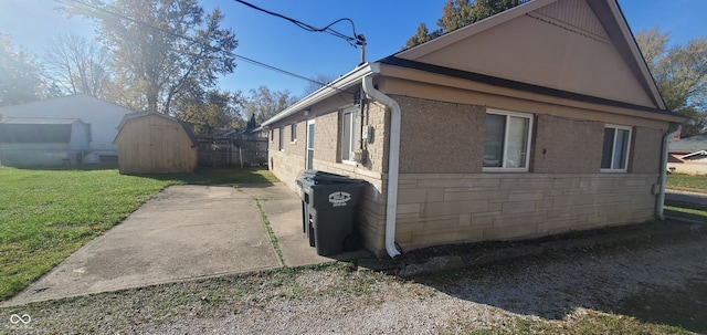 view of home's exterior featuring a patio area, a yard, and a storage unit