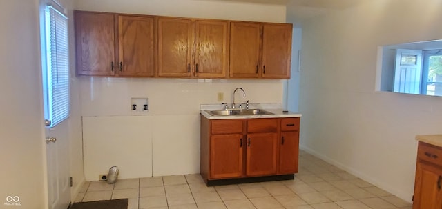 kitchen featuring light tile patterned flooring, sink, and a healthy amount of sunlight