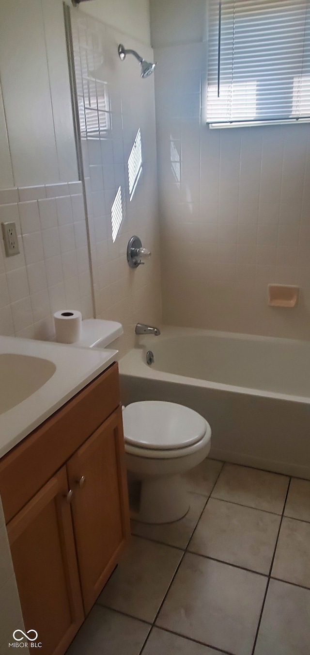 full bathroom with tile patterned flooring, toilet, tile walls, and bathing tub / shower combination