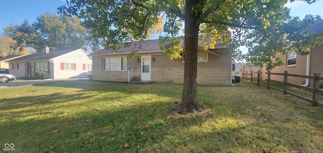 ranch-style house with central air condition unit and a front lawn