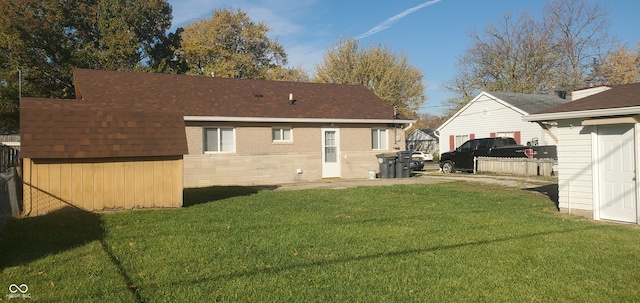 rear view of house with a storage shed and a yard