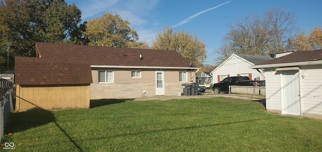 rear view of house featuring a yard and a storage shed