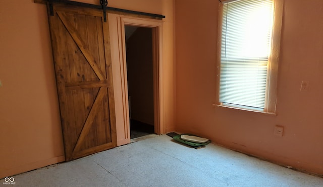 unfurnished bedroom featuring a barn door