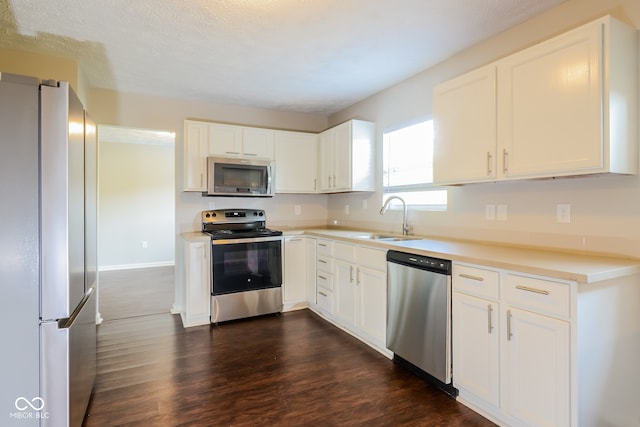 kitchen featuring dark hardwood / wood-style flooring, sink, white cabinets, and appliances with stainless steel finishes