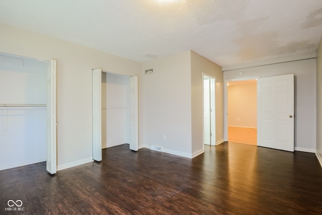 unfurnished bedroom with dark wood-type flooring