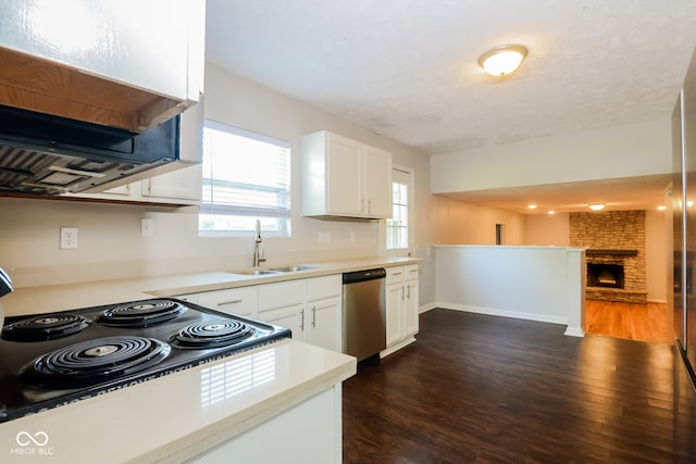 kitchen featuring dark hardwood / wood-style flooring, stainless steel dishwasher, a fireplace, sink, and white cabinets