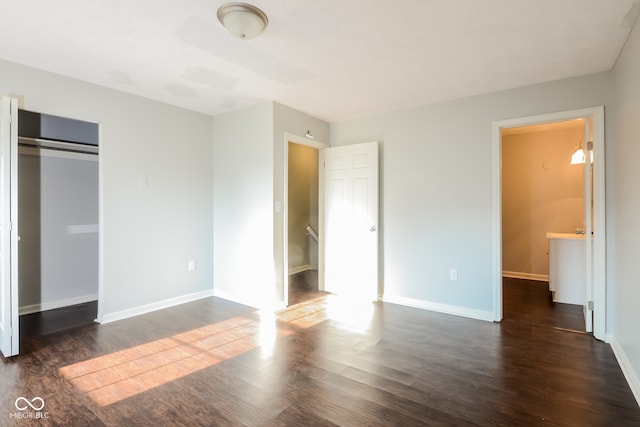 unfurnished bedroom with dark hardwood / wood-style flooring and a closet