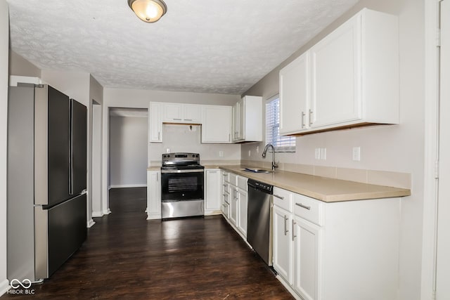 5060 Staughton Dr, Indianapolis, IN 46226 - kitchen featuring appliances with stainless steel finishes, white cabinets, light countertops, dark wood finished floors, and a textured ceiling