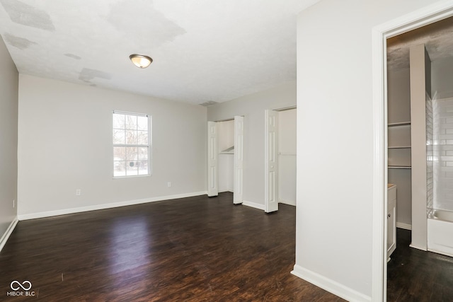 5060 Staughton Dr, Indianapolis, IN 46226 - unfurnished bedroom featuring dark wood finished floors, multiple closets, and baseboards