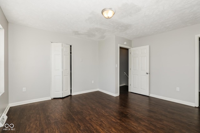 5060 Staughton Dr, Indianapolis, IN 46226 - unfurnished room featuring dark wood-style flooring, baseboards, and a textured ceiling