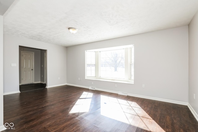5060 Staughton Dr, Indianapolis, IN 46226 - empty room featuring dark wood-style floors, baseboards, and a textured ceiling