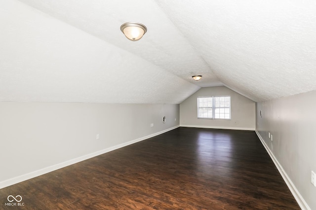 5060 Staughton Dr, Indianapolis, IN 46226 - additional living space with dark wood finished floors, lofted ceiling, baseboards, and a textured ceiling