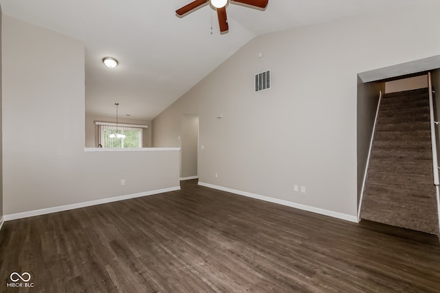 unfurnished room featuring ceiling fan with notable chandelier, vaulted ceiling, and dark wood-type flooring