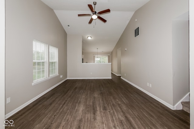 spare room featuring ceiling fan with notable chandelier, lofted ceiling, and dark wood-type flooring