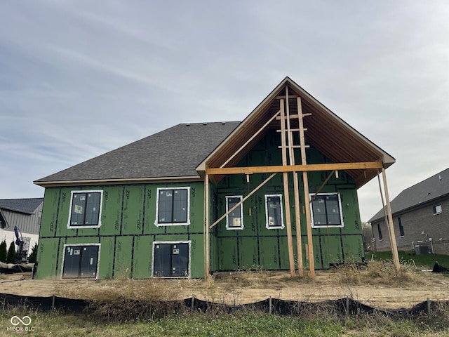 back of house featuring a shingled roof