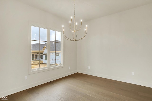 5469 Harness Dr, Greenwood, IN 46143 - unfurnished room with a chandelier, dark wood-style flooring, and baseboards