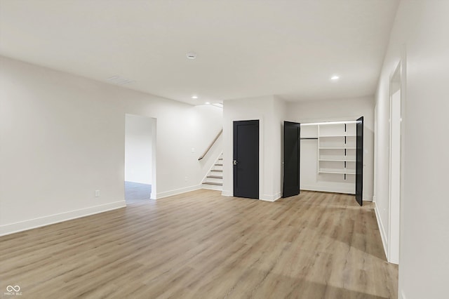 5469 Harness Dr, Greenwood, IN 46143 - unfurnished living room with stairs, light wood-type flooring, recessed lighting, and baseboards
