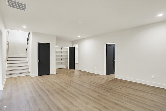 5469 Harness Dr, Greenwood, IN 46143 - unfurnished living room with baseboards, light wood finished floors, recessed lighting, stairs, and built in shelves