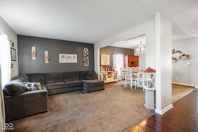 living room with a notable chandelier and dark wood-type flooring