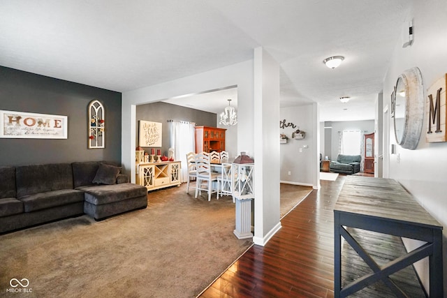 carpeted living room featuring a notable chandelier