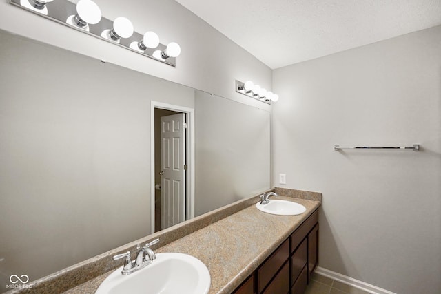 bathroom featuring a textured ceiling, tile patterned flooring, and vanity