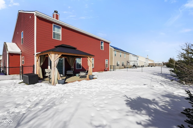 snow covered rear of property featuring a gazebo