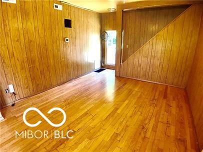 spare room with wooden walls and wood-type flooring