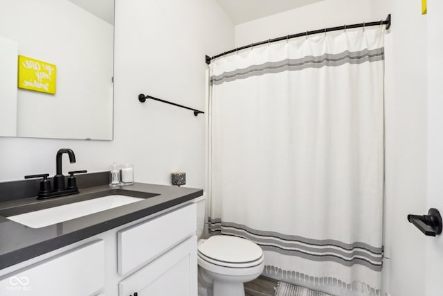 bathroom featuring wood-type flooring, vanity, and toilet