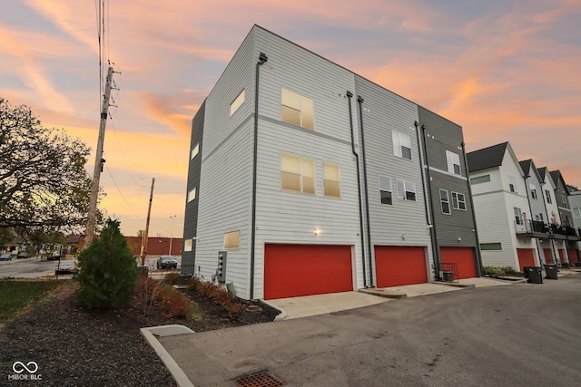 property exterior at dusk featuring a garage