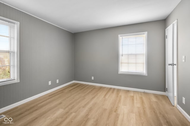 unfurnished room featuring a healthy amount of sunlight and light wood-type flooring