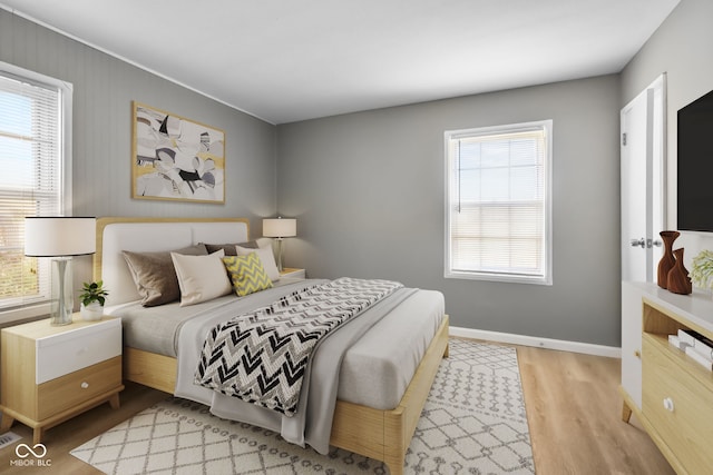 bedroom with multiple windows and light hardwood / wood-style floors