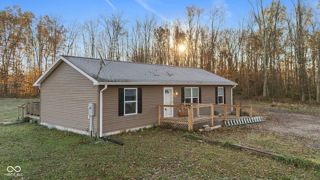 view of front facade featuring a front yard and a wooden deck