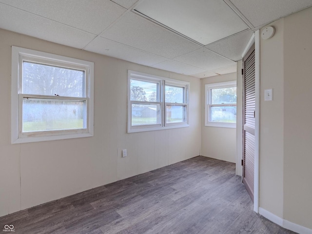 unfurnished room featuring a drop ceiling and dark hardwood / wood-style floors