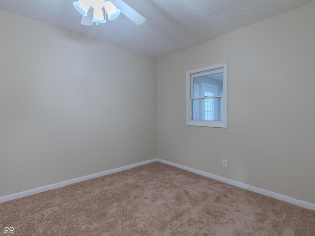 empty room with ceiling fan, a textured ceiling, and light carpet