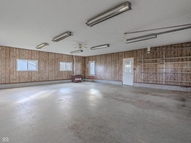 garage featuring wooden walls and ceiling fan