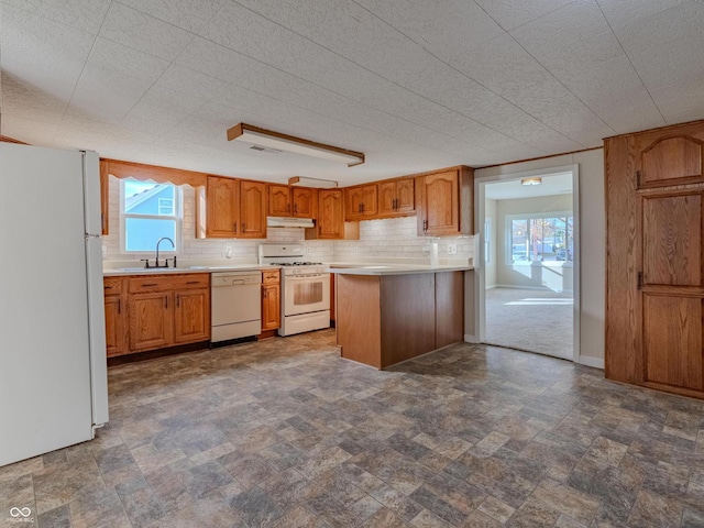 kitchen featuring tasteful backsplash, white appliances, sink, and a textured ceiling