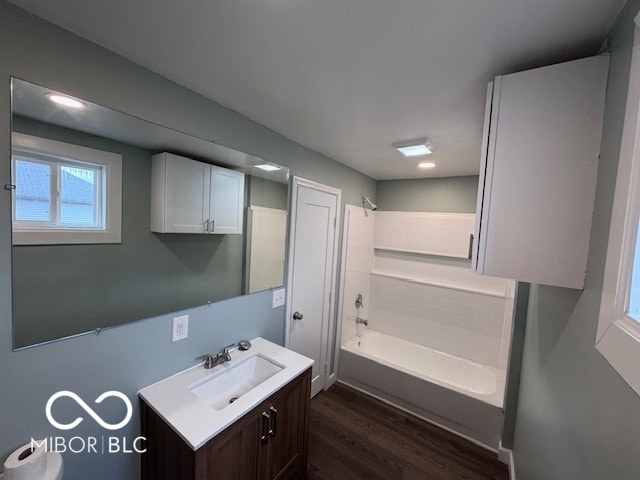 bathroom featuring washtub / shower combination, hardwood / wood-style flooring, and vanity