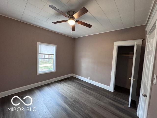 unfurnished bedroom with dark hardwood / wood-style flooring, a closet, ornamental molding, and ceiling fan