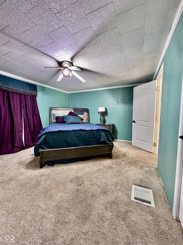 carpeted bedroom with ceiling fan, a textured ceiling, and ornamental molding