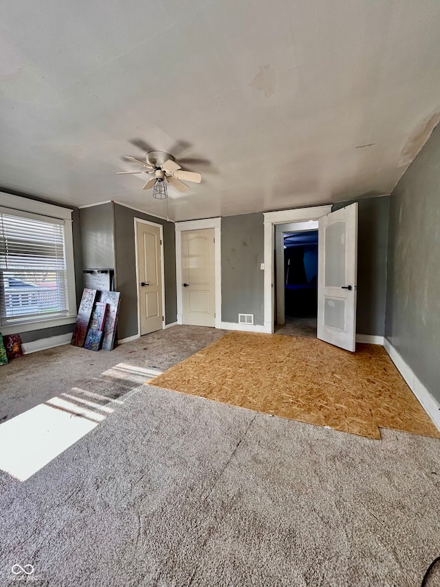 unfurnished bedroom with ceiling fan and carpet floors