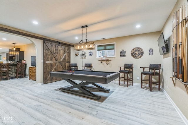 playroom with a barn door, light hardwood / wood-style floors, and pool table