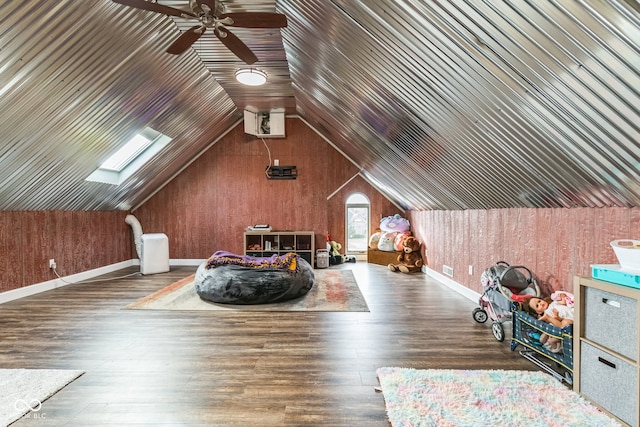 bonus room featuring dark hardwood / wood-style floors, wooden walls, and vaulted ceiling with skylight