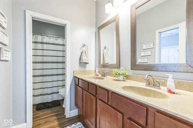 bathroom with curtained shower, hardwood / wood-style floors, vanity, and toilet