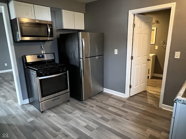 kitchen featuring light wood-type flooring, white cabinetry, and appliances with stainless steel finishes