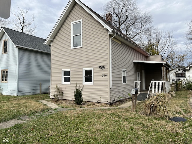 rear view of property featuring a lawn